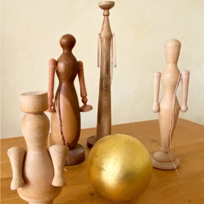 Holzfiguren mit Goldkugel